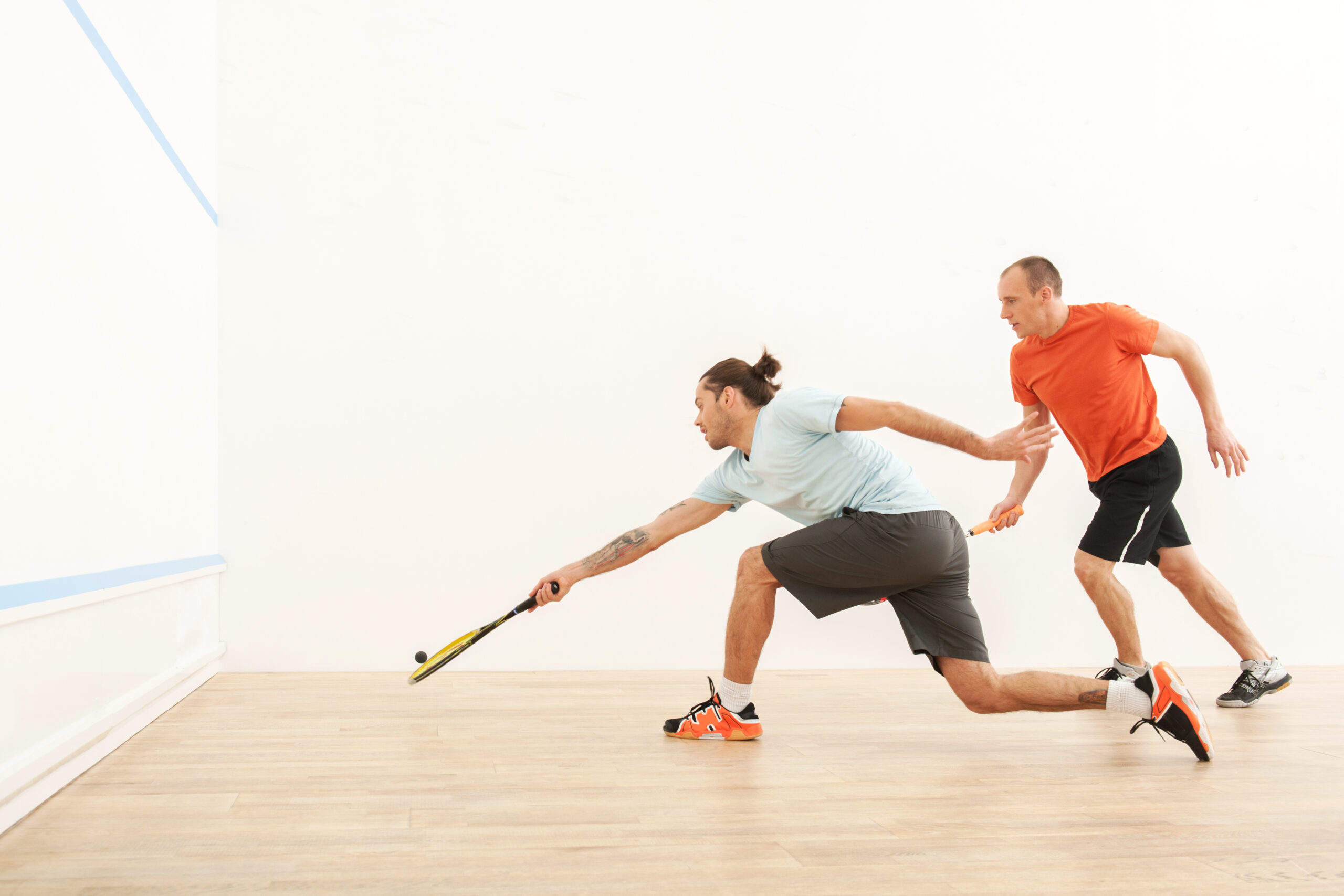 Two men playing match of squash. Squash players in action on squash court